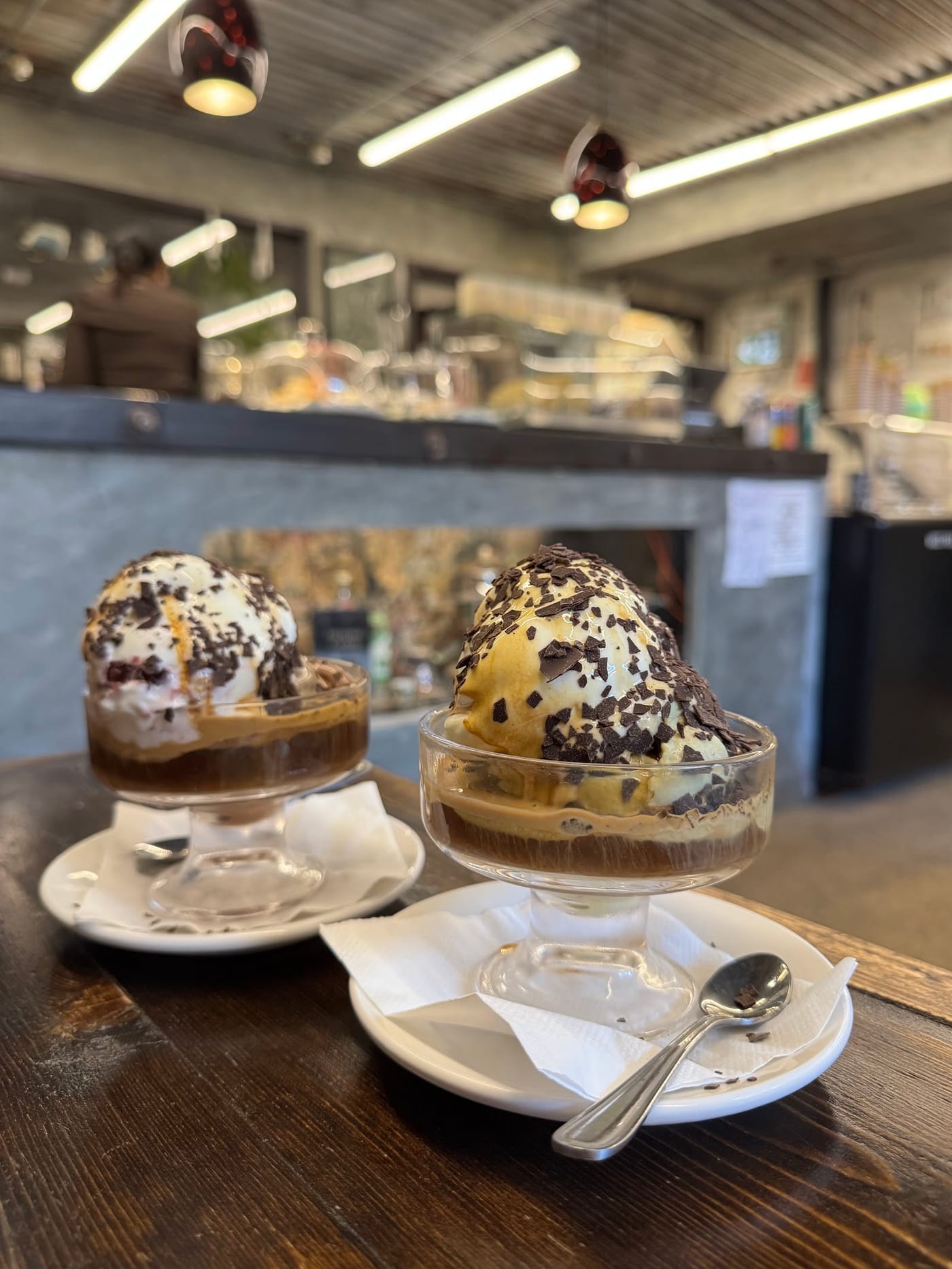 Two affogati in fluted glasses, chocolate flaked on top